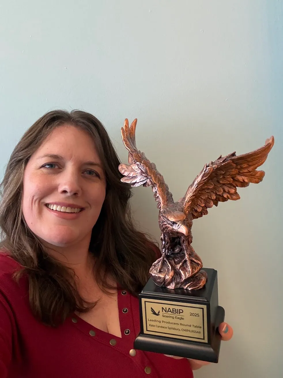 Kate Spilsbury holding a NABIP award