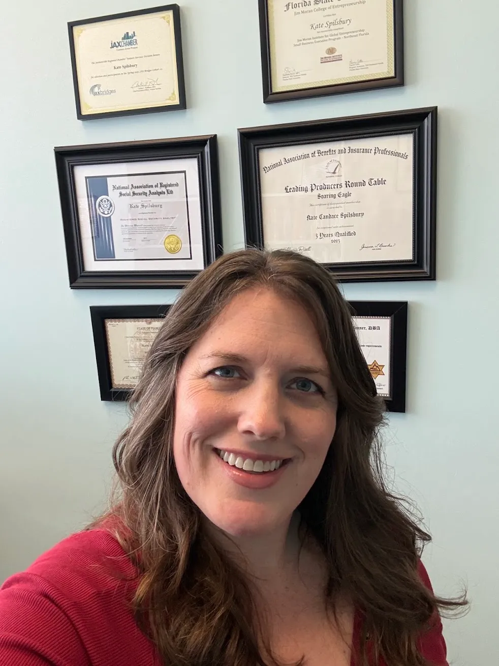 Kate Spilsbury in front of her framed licences and certificates
