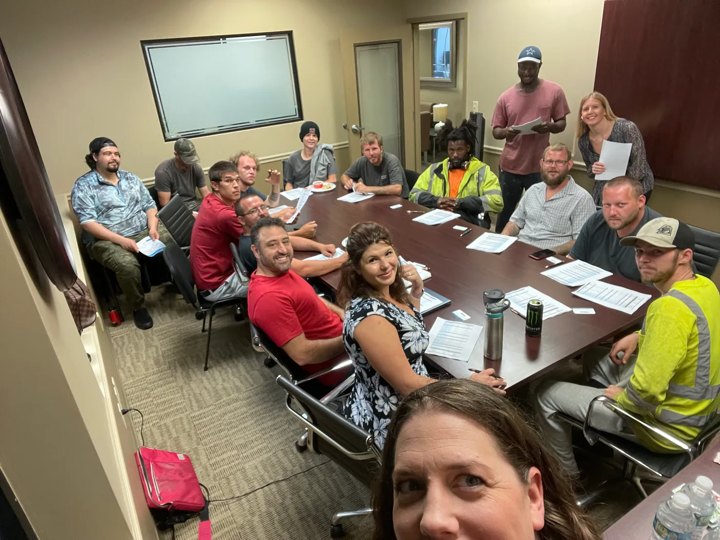 Kate Spilsbury running a group benefits enrollment meeting with a company's crew around a conference table