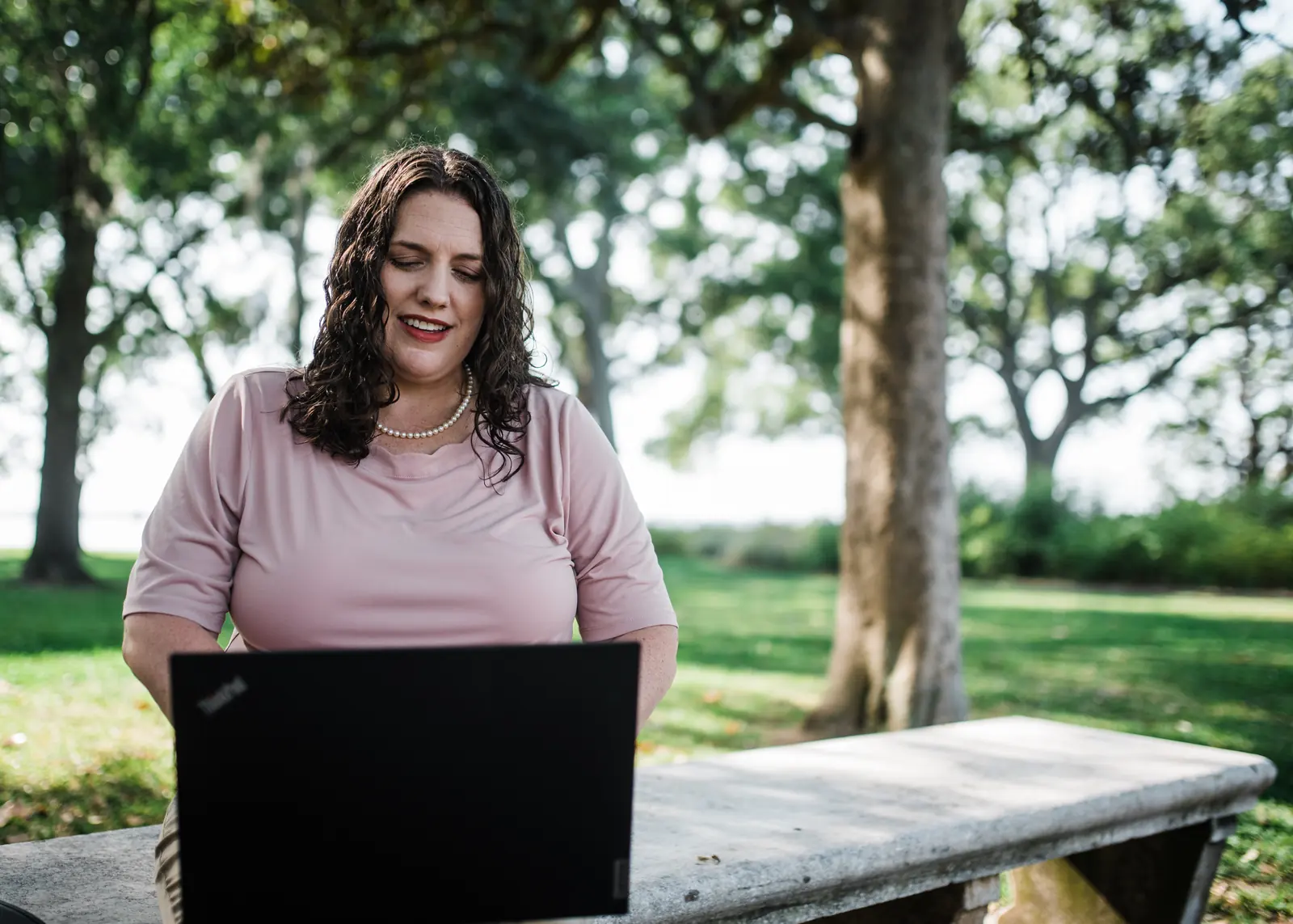 Kate Spilsbury working on her laptop outdoors