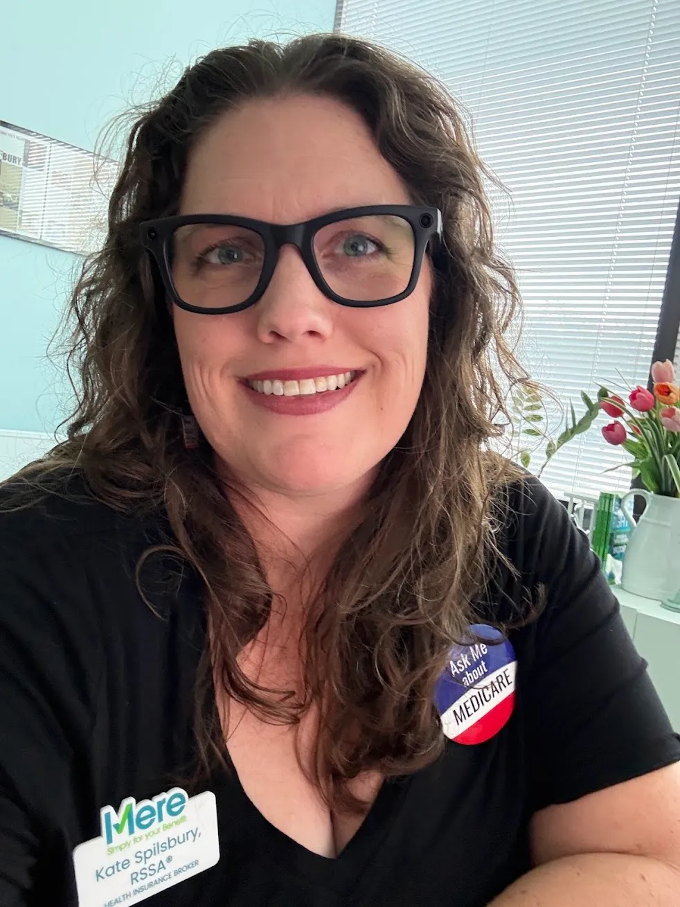 Kate Spilsbury wearing her Mere Benefits name badge and an Ask Me About Medicare button